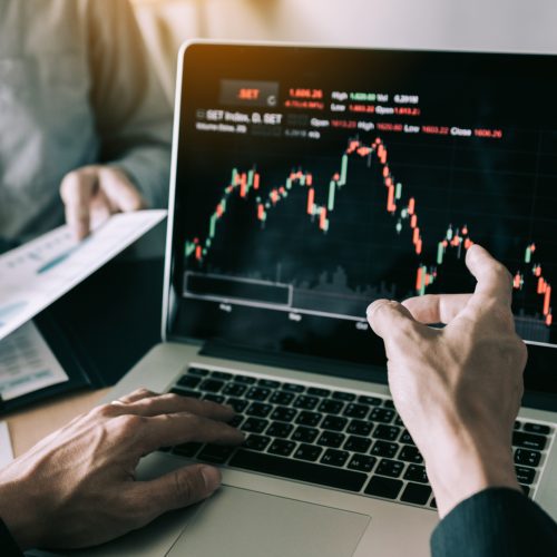 Investors are pointing to laptops that have investment informati Investors are pointing to laptops that have investment information stock markets and partners taking notes and analyzing performance data.