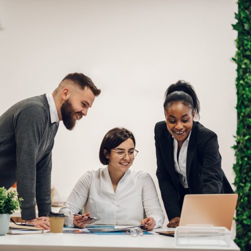 Young and creative start-up team discussing ideas in a board room. Group of multiracial people working together during business meeting.