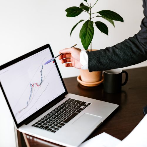 stock trader price trend graph analyzing on laptop and smartphone. Investment broker trading bitcoin crypto currency using phone and laptop.