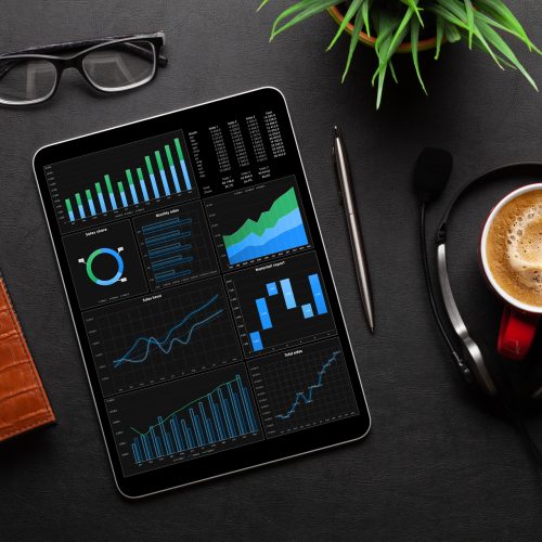 Tablet with blank screen Tablet with business reports and charts, coffee cup and office supplies on desk. Top view flat lay