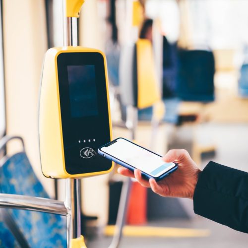 Girl paying conctactless phone for the tram ticket. Payment by card, Bank transfer .