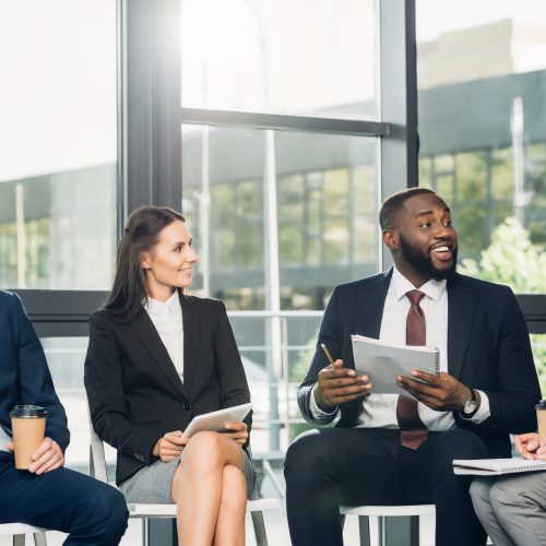 smiling multicultural businesspeople having meeting in conference hall smiling multicultural businesspeople having meeting in conference hall