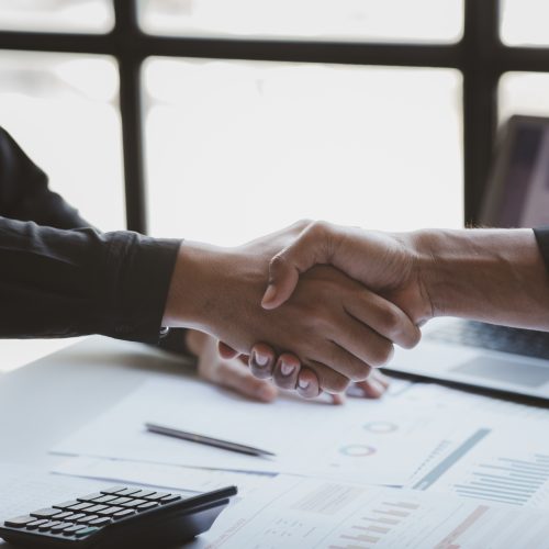 Business investor group holding hands, Two businessmen are agreeing on business together and shaking hands after a successful negotiation. Handshaking is a Western greeting or congratulation.