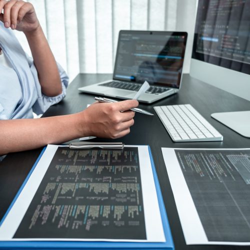 Female Programmer working in software javascript computer in IT office, Writing codes and data code website and coding database technologies to find solution to problem.