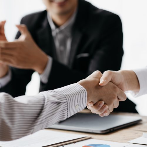 Business investor group holding hands, Two businessmen are agreeing on business together and shaking hands after a successful negotiation. Handshaking is a Western greeting or congratulation.