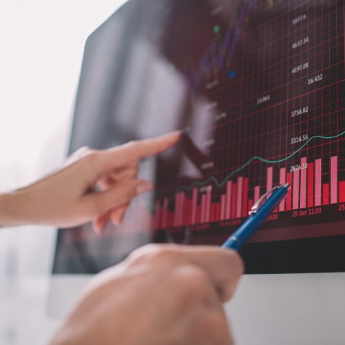 Selective focus of data analysts pointing on graphs on computer monitor while testing security of