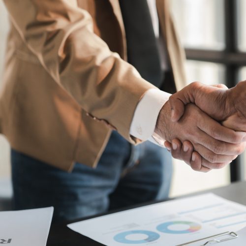 Business investor group holding hands, Two businessmen are agreeing on business together and shaking hands after a successful negotiation. Handshaking is a Western greeting or congratulation.