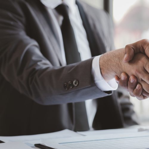 Business investor group holding hands, Two businessmen are agreeing on business together and shaking hands after a successful negotiation. Handshaking is a Western greeting or congratulation.