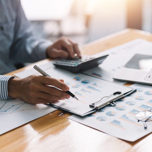 Business man using a calculator to check income and budget in a Business man using a calculator to check income and budget in a company.