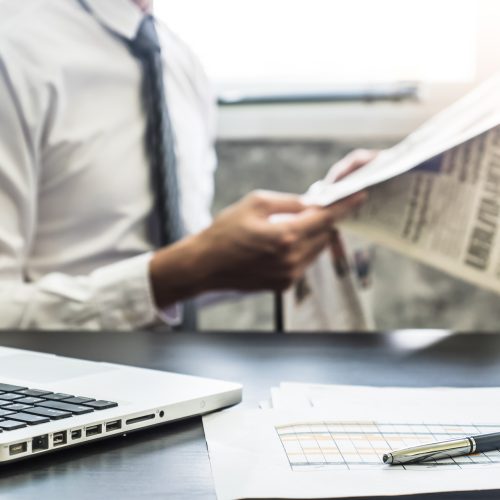 Businessman reading a newspaper on the desk. Selective focus Businessman reading a newspaper on the desk. Selective focus